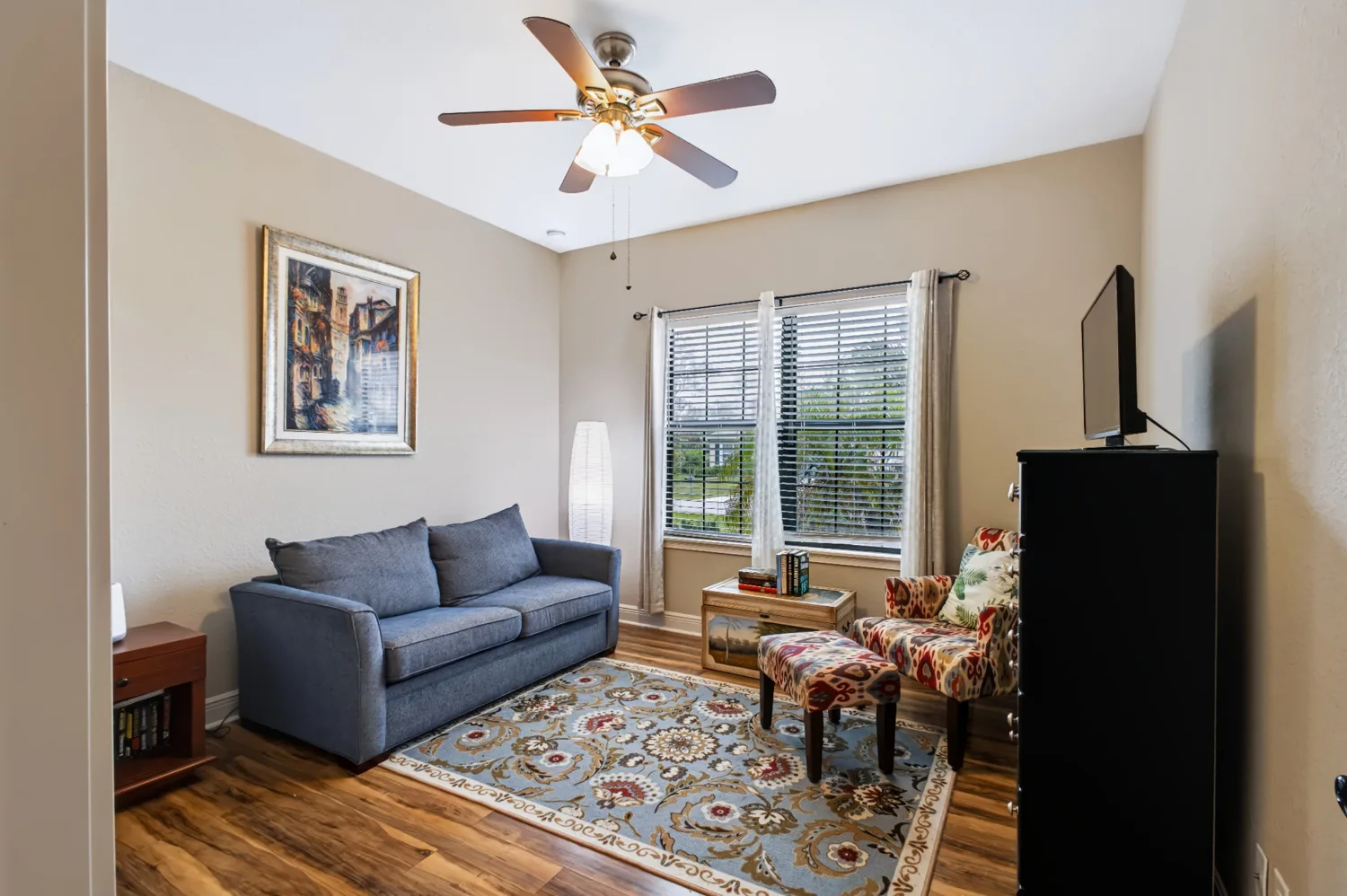 Living room with blue seating and patio doors