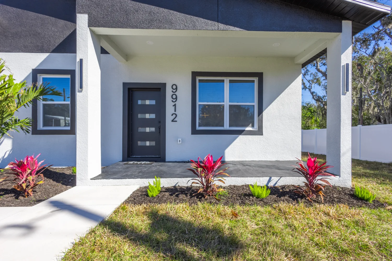 Blue-accented front entry surrounded by Florida landscaping
